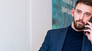 Man on a phone call in an office setting, representing global client enquiries. Man on a phone call in an office setting, representing global client enquiries.