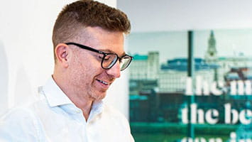 Smiling man reviewing documents, symbolizing trust and openness in investor relations. Smiling man reviewing documents, symbolizing trust and openness in investor relations.