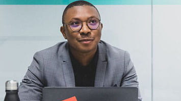 Man in glasses at a table with a laptop, representing press and media enquiries. Man in glasses at a table with a laptop, representing press and media enquiries.