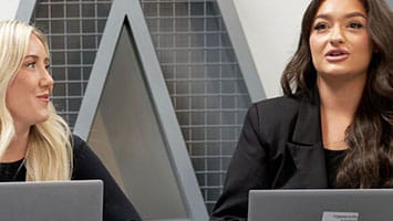 Two people build patterns on a LEGO wall, symbolizing robotics, automation, and creative system design. Two people build patterns on a LEGO wall, symbolizing robotics, automation, and creative system design.