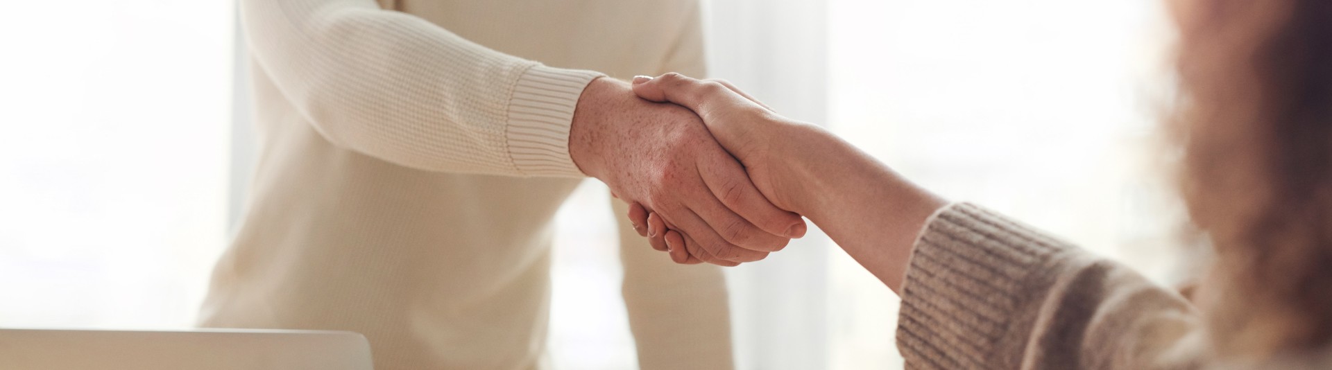 BANNER - Two employees shaking hands BANNER - Two employees shaking hands