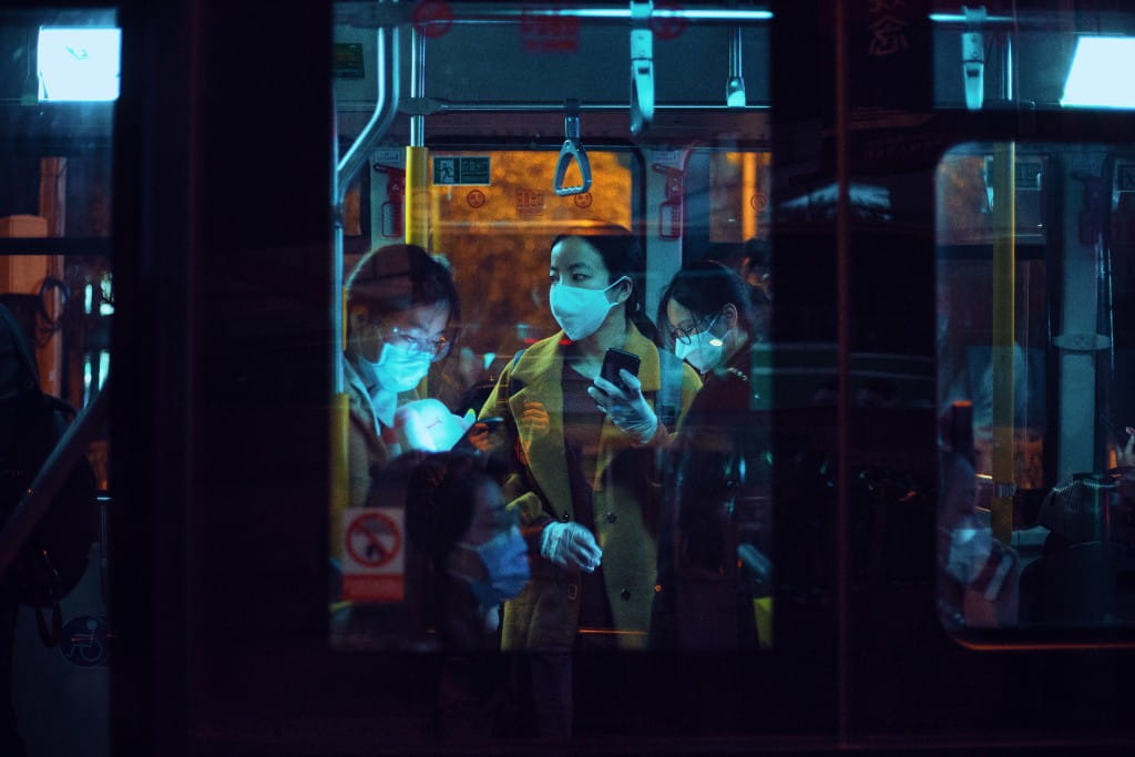 CARD IMAGE - People with masks riding a bus